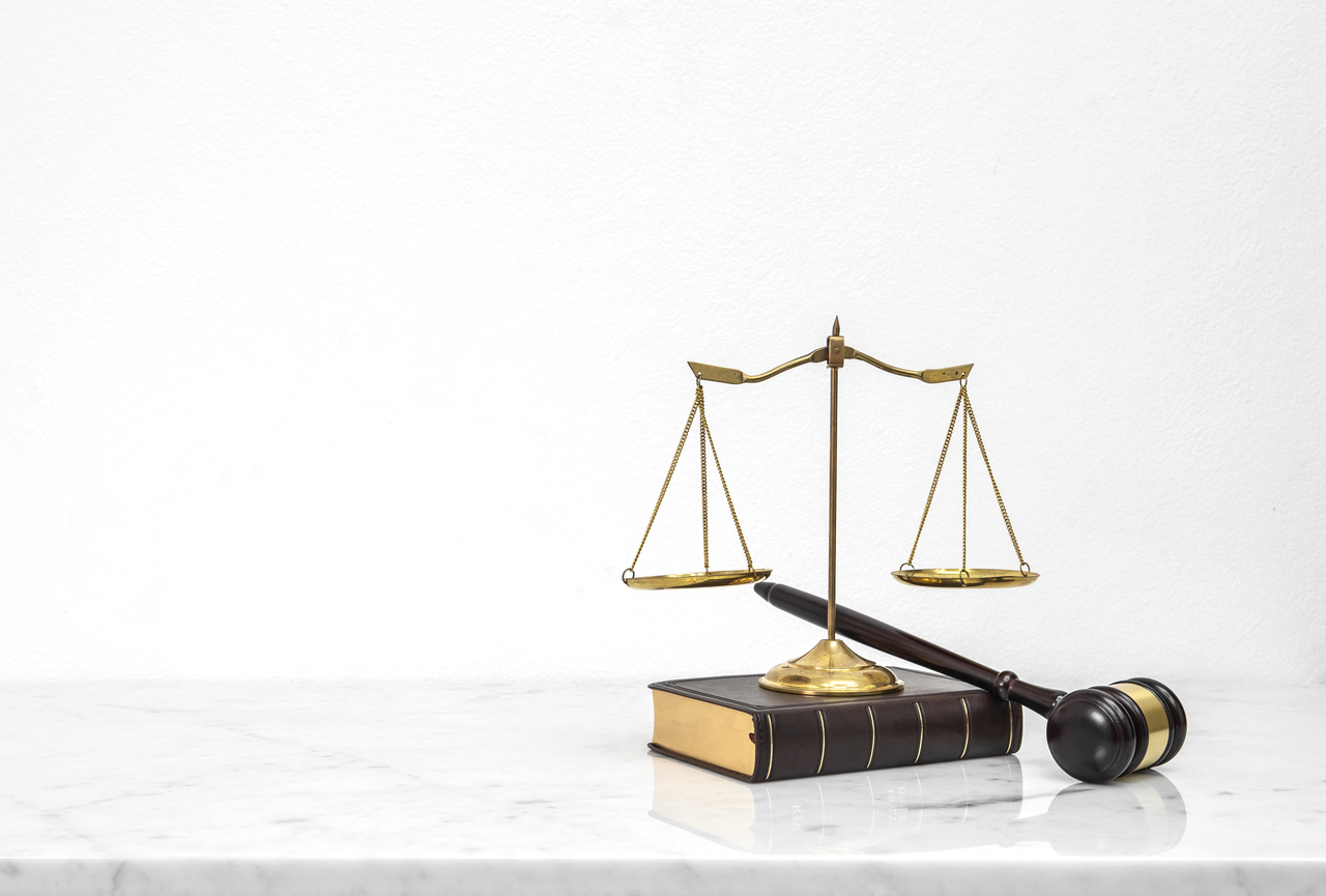 Wooden gavel and law book put on white marble table top counter with copy space.