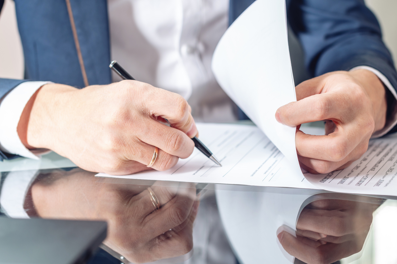 businessman sitting at the table signing documents in the office
