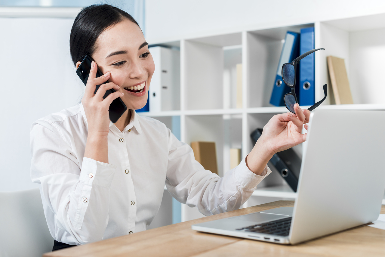 girl talking on the phone while on the laptop