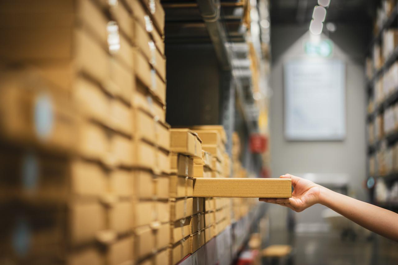 A woman picking a box out of a warehouse